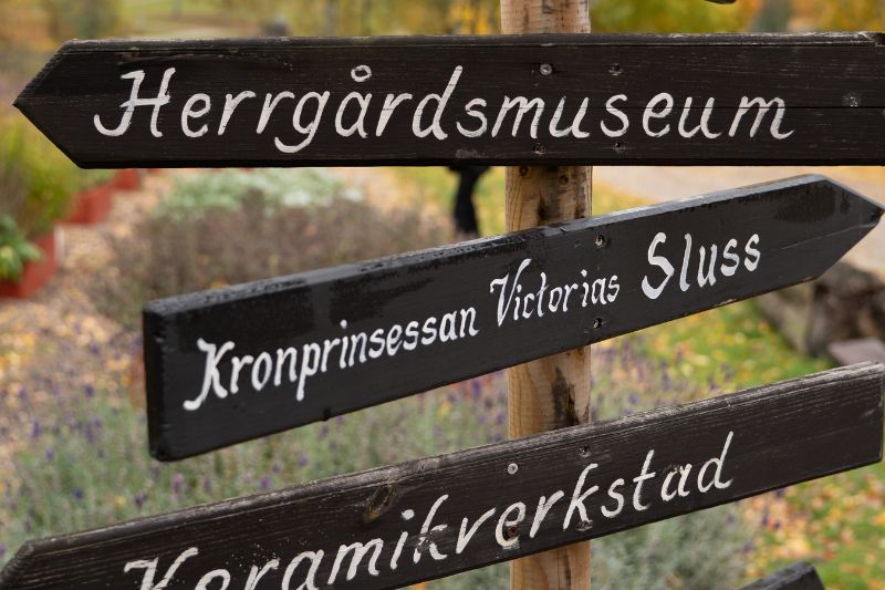 Skyltarna visar vägen till Herrgårdsmuseet, Kronprinsessan Victorias sluss och keramikverkstaden – några av områdets sevärdheter.