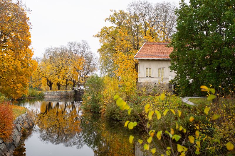 Höstens färger speglar sig i vattnet och ramar in den historiska bebyggelsen. En vacker miljö för en promenad och upptäcktsfärd.
