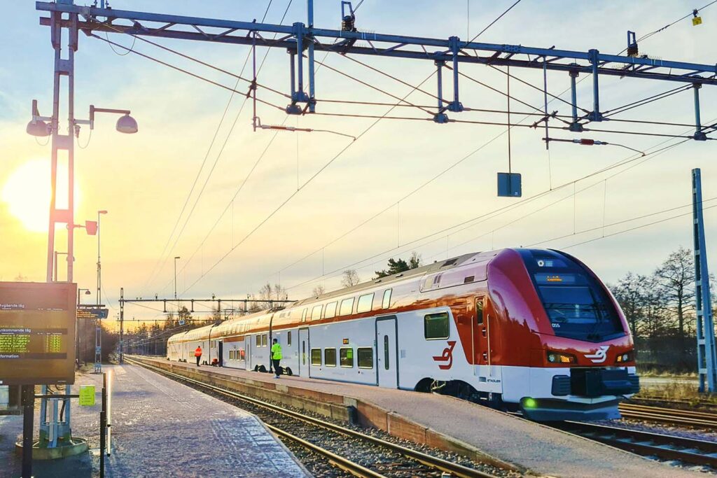 Tåg i Bergslagens dubbeldäckare ER1 vid Virsbo station. Solen står lågt på himlen