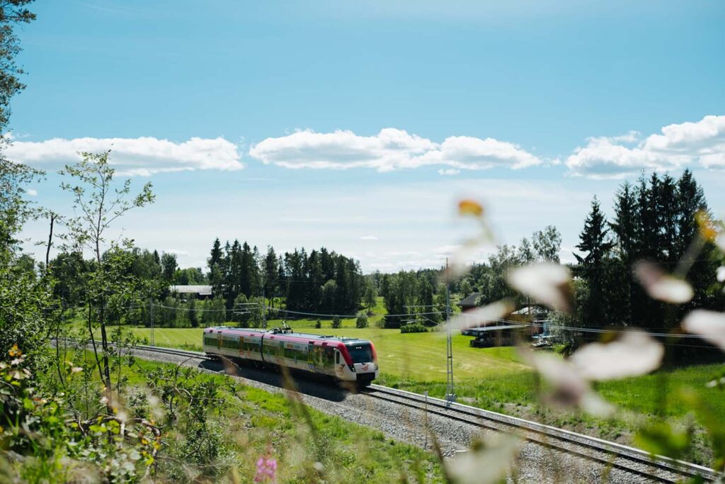 Tåg i Bergslgens tåg i en grönskande miljö